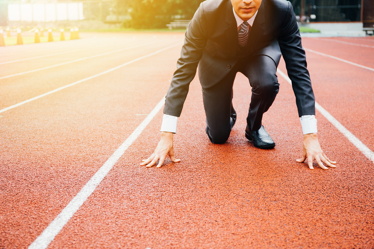 Business man preparing to run on the competition running track