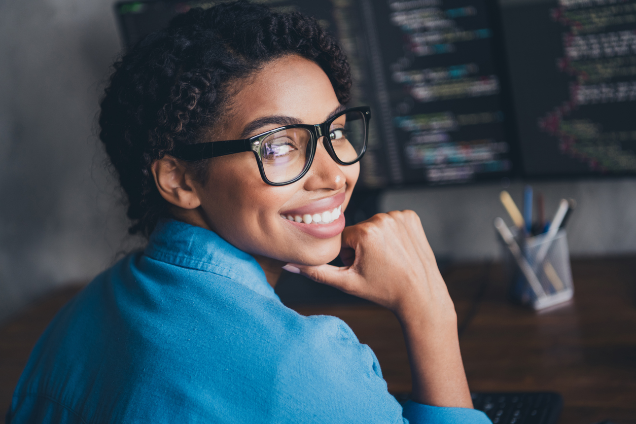 Photo of pretty young girl typing keyboard monitors coding thoughtful wear blue shirt coworking programmer successful nice light office